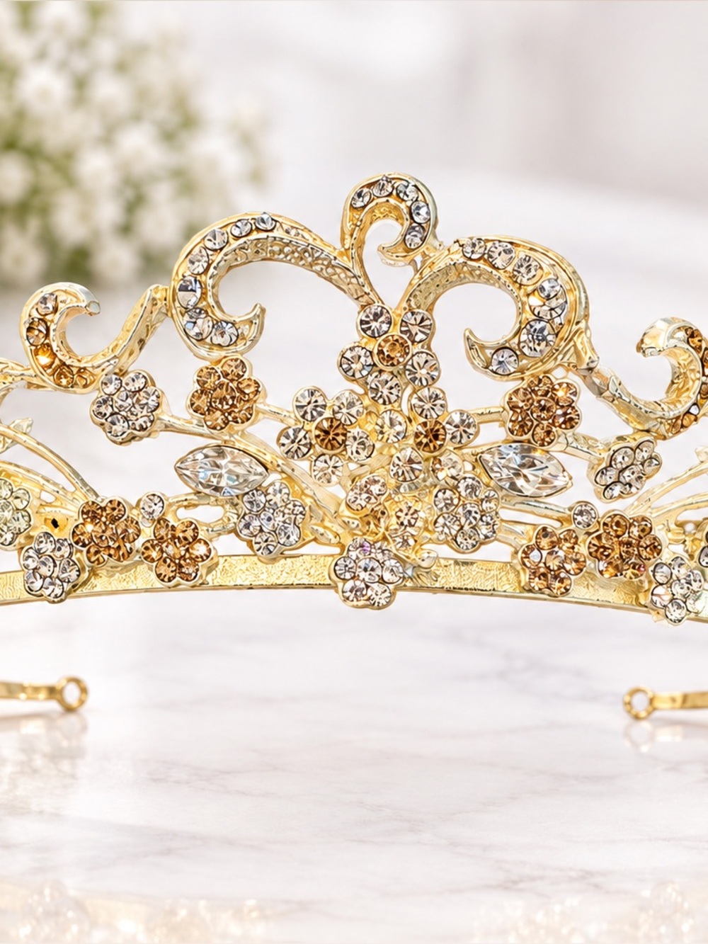 This is a substantial, heavyweight tiara with an ornate gold-tone floral and scr